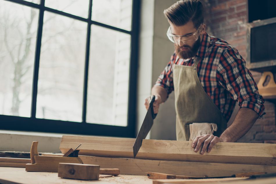 young-stylish-cabinet-maker-with--glasses-and-hairstyle--strong--handsome-craftsman-holding-saw-and-wood-blank-at-workplace-944613244-5af9afc2a18d9e003c17040c